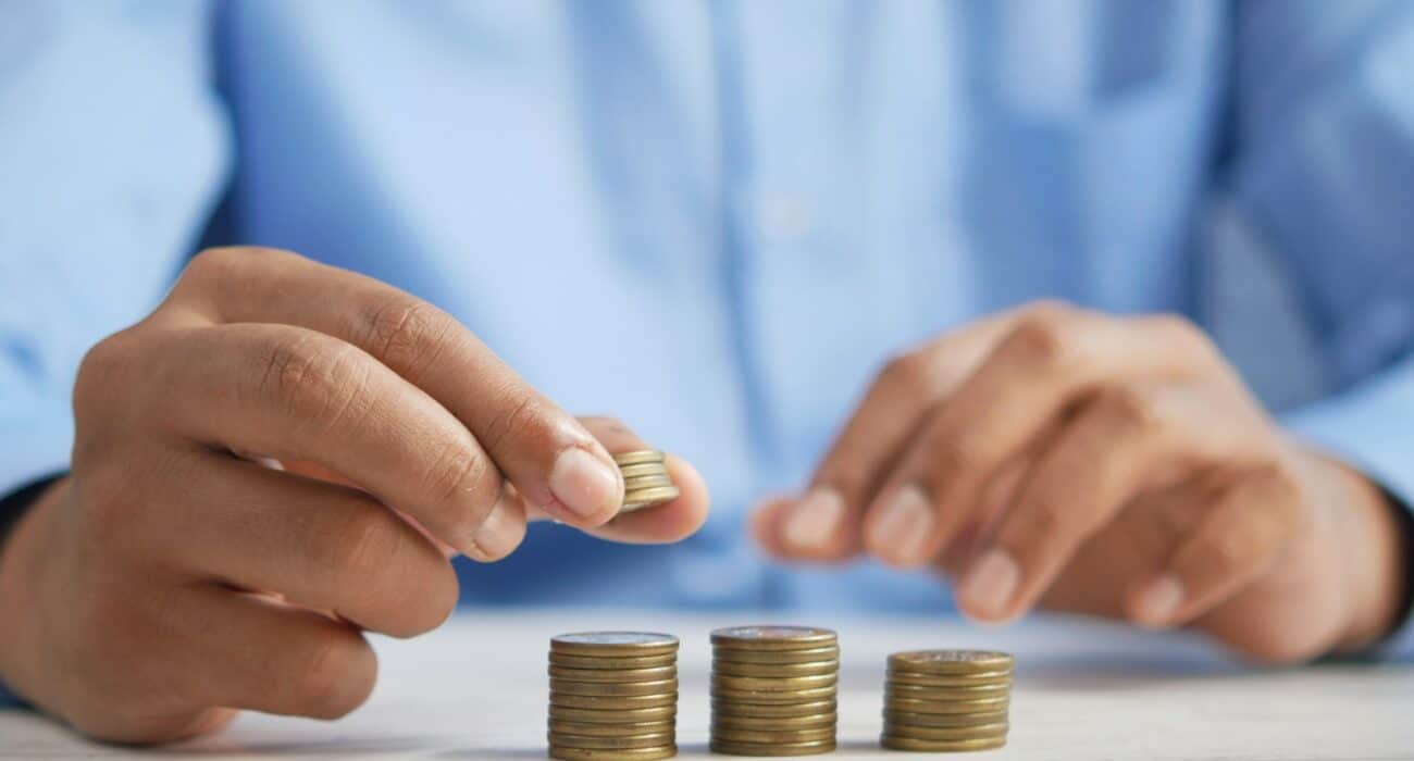 a person stacking coins on top of a table